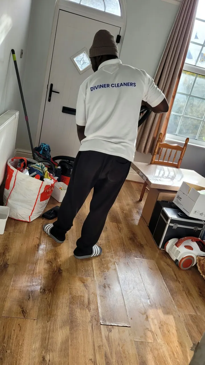 Diviner Cleaners team member cleaning a wooden hallway floor